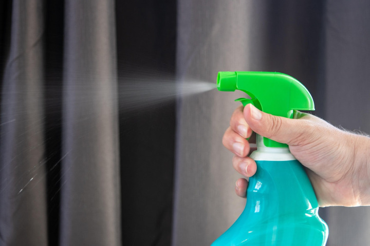 worker cleaning and sanitizing playground equipment